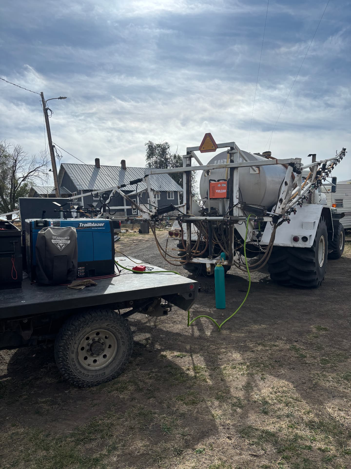 Kobar Welding mobile rig set up beside an agricultural sprayer, welding on the sprayer in the field