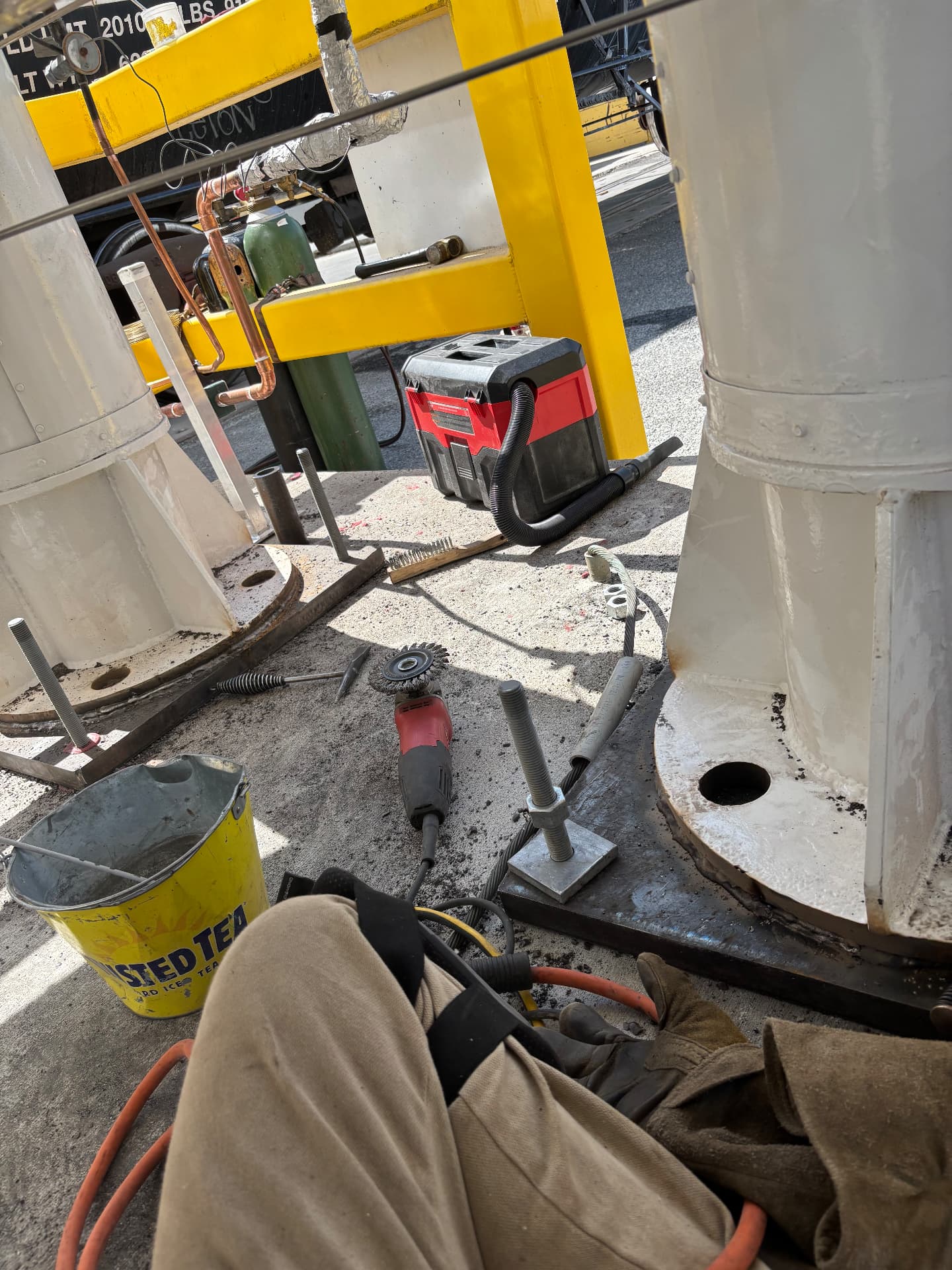Steel column base on a plate with anchor bolts staged for installation