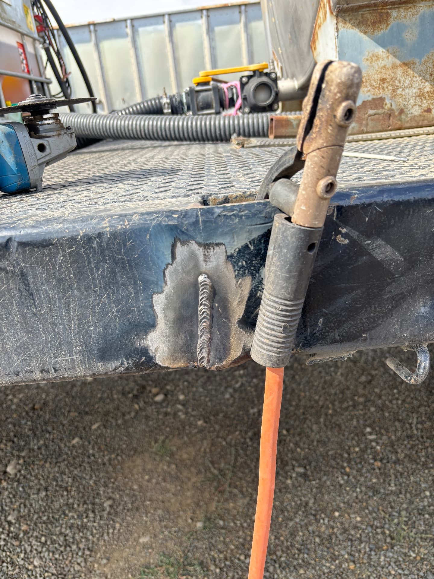 Weld repair on trailer steel next to a hold-down clamp